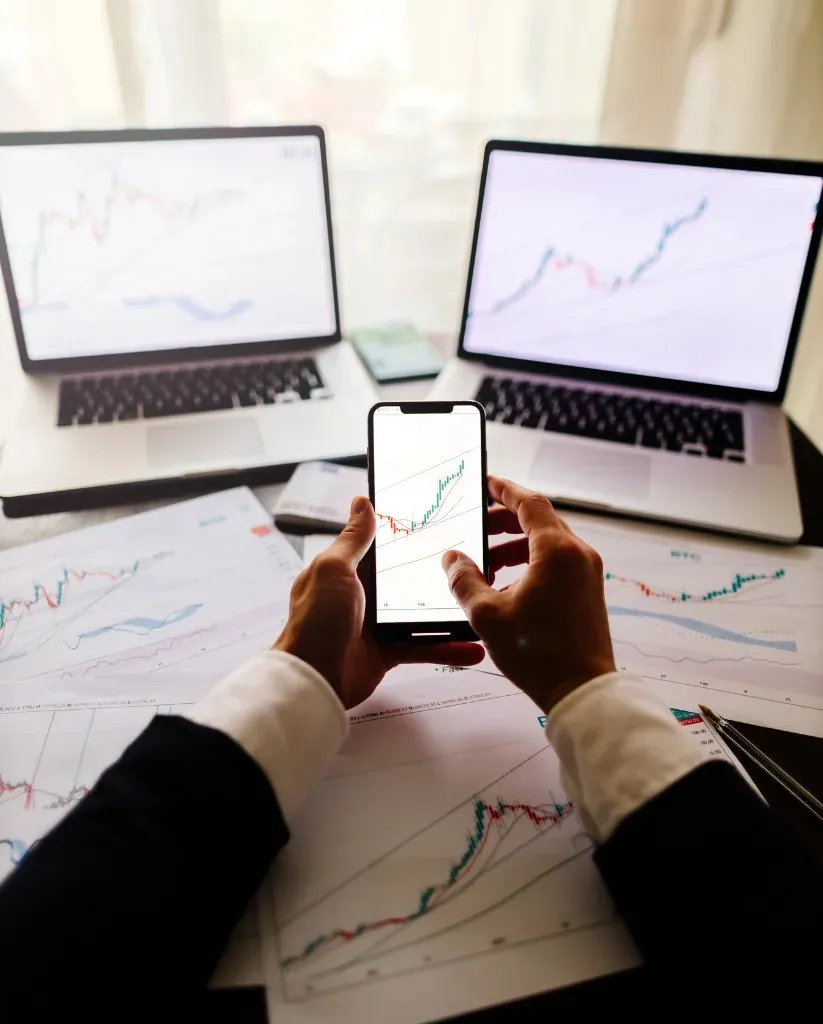Trader analyzes charts dual monitors.